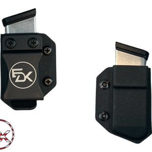 May include: Two black plastic magazine holders with a silver magazine inside. The holders have a screw on each side and the logo "FDX" on the front.