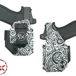 May include: A black and white patterned gun holster with a black clip and a silver logo that says "FDX".