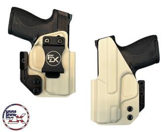 Pode incluir: Dois coldres moldados em tom esbranquiçado, cada um contendo uma pistola semiautomática preta. O coldre esquerdo possui um clipe de cinto preto com um logotipo circular exibindo as letras FDK. Um logotipo circular com as letras FDK sobre uma bandeira dos EUA é visível.