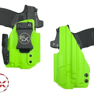 May include: Two green holsters for a handgun with a black clip and a black gun. The holsters have a textured surface and are made of a durable material.