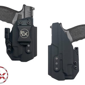 May include: Two black molded holsters, each containing a handgun with a textured grip. The left holster features a belt clip with a circular logo displaying the letters FDK. A matching circular logo with an American flag pattern is visible below.