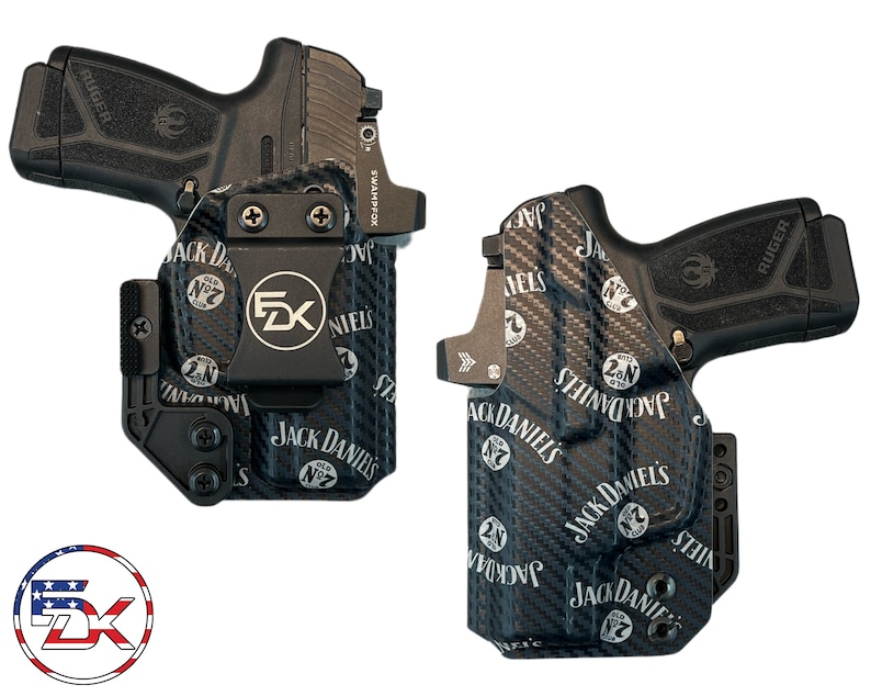 May include: Two black handguns with holsters. The holsters are black with a carbon fibre pattern and the Jack Daniel's logo. The holsters have a metal clip with the letters "FZK" on them. The handguns are black with the Ruger logo.