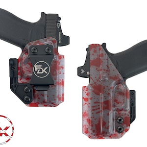 May include: A red and gray gun holster with a blood splatter design. The holster has a black clip and a black metal plate with the letters "FDX" on it.