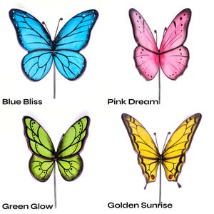 Puede incluir: Cuatro estacas de jard&iacute;n con forma de mariposa de colores. Las mariposas son azules, rosas, verdes y amarillas, cada una con un dise&ntilde;o &uacute;nico. Est&aacute;n montadas sobre estacas de metal. El texto de la imagen dice "Blue Bliss", "Pink Dream", "Green Glow" y "Golden Sunrise".