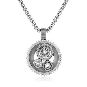 Puede incluir: Collar con colgante plateado con diseño de engranaje. El colgante presenta un engranaje exterior grande con tres engranajes más pequeños en el interior. El collar tiene una cadena con diseño de eslabones redondos, adecuado para el uso diario.