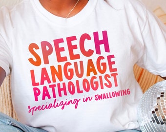 May include: A white t-shirt with the text "Speech Language Pathologist specialising in Swallowing" printed in a gradient of pink and orange.