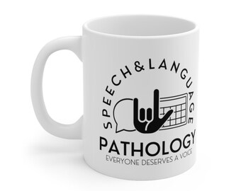 Op de afbeelding: Een witte keramische mok met een zwart ontwerp dat "Speech & Language Pathology" zegt met een spraakballon, een hand die het "Ik hou van je"-teken in Amerikaanse gebarentaal maakt en een kalender. De tekst onder het ontwerp zegt "Everyone deserves a voice."