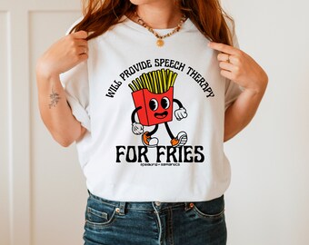 Può includere: Maglietta bianca con un'immagine di cartone animato di un contenitore di patatine fritte con un viso e delle gambe. Il testo "Will provide speech therapy for fries" è stampato sulla maglietta.