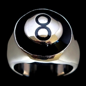 May include: A silver ring with a black and white 8-ball design. The ring is a classic style with a smooth band.