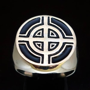 May include: A silver ring with a black enamel Celtic knot design. The knot is a circle with four arms that intersect in the center. The ring is oval shaped.