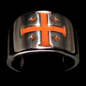 Könnte beinhalten: Ein silberner Ring mit einem orangefarbenen Emaille-Kreuz und vier kleineren Kreuzen darum herum.