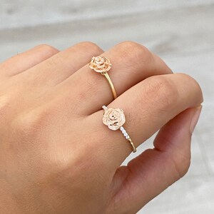 Pu&ograve; includere: Due anelli d'oro a forma di rosa. Un anello ha un design semplice a forma di rosa, mentre l'altro ha un design a forma di rosa con piccoli pietre intorno alla fascia.