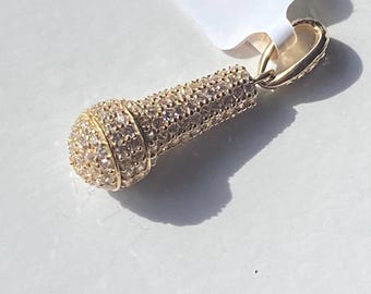 May include: Gold-tone microphone pendant charm with clear cubic zirconia stones.