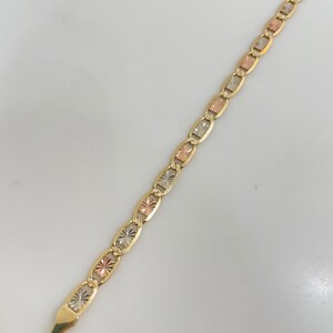 May include: A gold chain bracelet with a mariner link design. The chain is made of three different colors of gold: yellow, white, and rose.