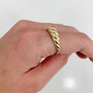 May include: A set of three ceramic mugs with a speckled, matte finish. The mugs are in shades of cream, light brown, and dark brown. Each mug has a simple, minimalist design and a rounded handle.