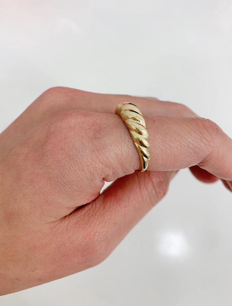 May include: A set of three ceramic mugs with a speckled, matte finish. The mugs are in shades of cream, light brown, and dark brown. Each mug has a simple, minimalist design and a rounded handle.