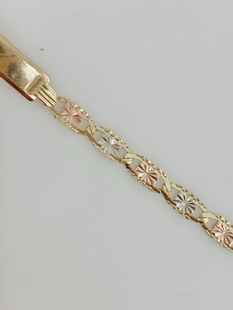 May include: Gold-toned bracelet featuring a series of textured, diamond-shaped links in yellow, rose, and white gold. The bracelet has a rectangular clasp. The design is intricate and eye-catching, suitable for everyday wear or special occasions.
