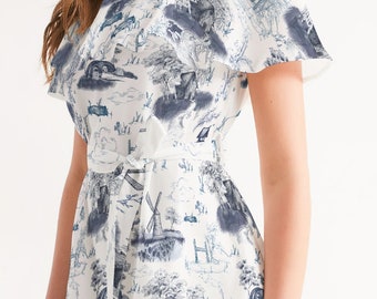 May include: A white off-the-shoulder dress with a blue and white print of a countryside scene. The dress has a ruffled neckline and a tie at the waist.
