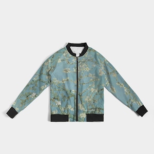 May include: A blue bomber jacket with a floral print. The print features white flowers and branches on a light blue background.