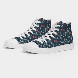 May include: A pair of white high-top canvas shoes with a dark blue background featuring a repeating pattern of red birds and white flowers.