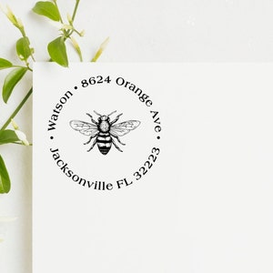 May include: A white envelope with a black and white bee illustration and the text "Watson 8624 Orange Ave. Jacksonville FL 32223" in a circle.