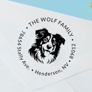 May include: A black and white round return address stamp with a border. The stamp features a black and white silhouette of a Border Collie dog's head. The text on the stamp reads "THE WOLF FAMILY", "89012", "Henderson, NV", and "854 Stally Ave."