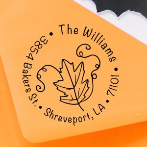 May include: A round return address stamp with a black and white illustration of a leaf with swirls. The text reads "The Williams, 1011 Bakers St., Shreveport, LA 71101."