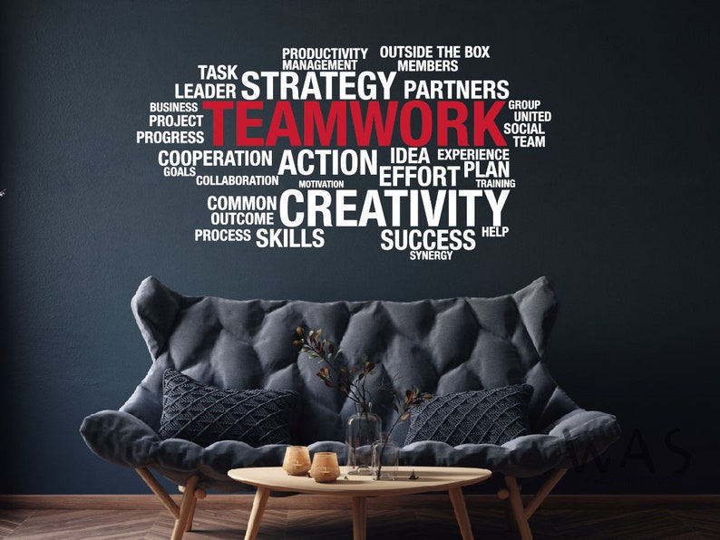 May include: A black and white word cloud with the word "Teamwork" in red. The word cloud includes words related to teamwork, such as strategy, action, creativity, success, and collaboration. The word cloud is displayed on a dark blue wall behind a gray couch.