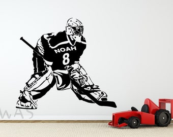 May include: Black and white silhouette of a hockey goalie in action, wearing a jersey with the name "Noah" and the number "8" on the front. The goalie is in a crouched position, holding a hockey stick and wearing a mask.