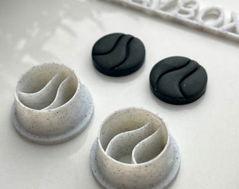Könnte beinhalten: Zwei weiße Silikonformen mit einem wellenförmigen Design und zwei schwarze Silikonformen mit dem gleichen wellenförmigen Design. Die Formen werden zur Herstellung von Kunsthandwerk aus Harz verwendet.