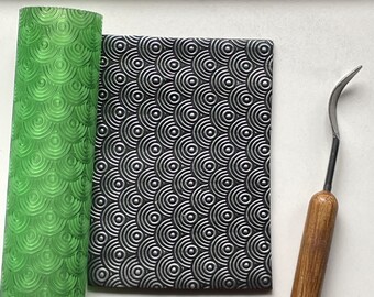 May include: A green patterned rolling pin and a black and silver patterned clay sheet. A wooden-handled clay tool is also present. The word "LAYBOX.CA" is displayed in white letters above the items.