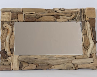 Peut inclure: Un miroir rectangulaire doté d'un cadre composé de divers morceaux de bois flotté patiné dans des tons de beige, de brun et de sable. Le cadre est formé de multiples petits segments de bois irréguliers entourant la vitre centrale.