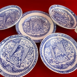 May include: Set of six blue and white porcelain plates with a floral design and a scene of a person in a cottage. The plates are perfect for serving tea or coffee.