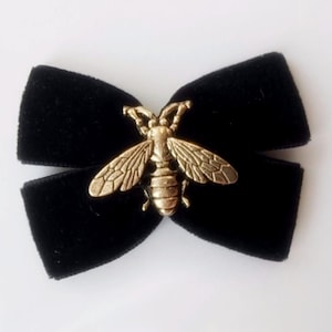 May include: Black velvet bow with a gold bee charm.