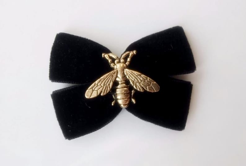 May include: Black velvet bow with a gold bee charm.