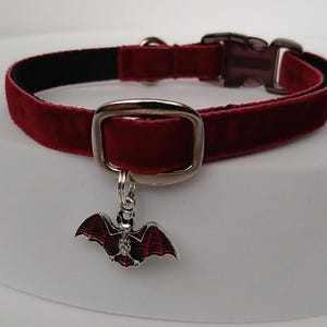 Puede incluir: Un collar para mascotas de terciopelo burdeos con interior negro. El collar presenta una hebilla plateada y un dije decorativo de murci&eacute;lago con detalles de esmalte rojo y negro. Un accesorio elegante para mascotas.