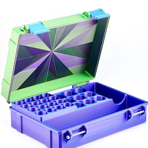 May include: Open, purple and green storage case with a geometric design on the inside lid. The case has a tray with multiple circular compartments. The case is open, revealing the interior.