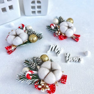 May include: Christmas-themed hair accessories featuring a cotton flower, pine cones, and a red polka-dot bow. Accented with gold glitter balls and candy canes. The text "My bows" is also visible.