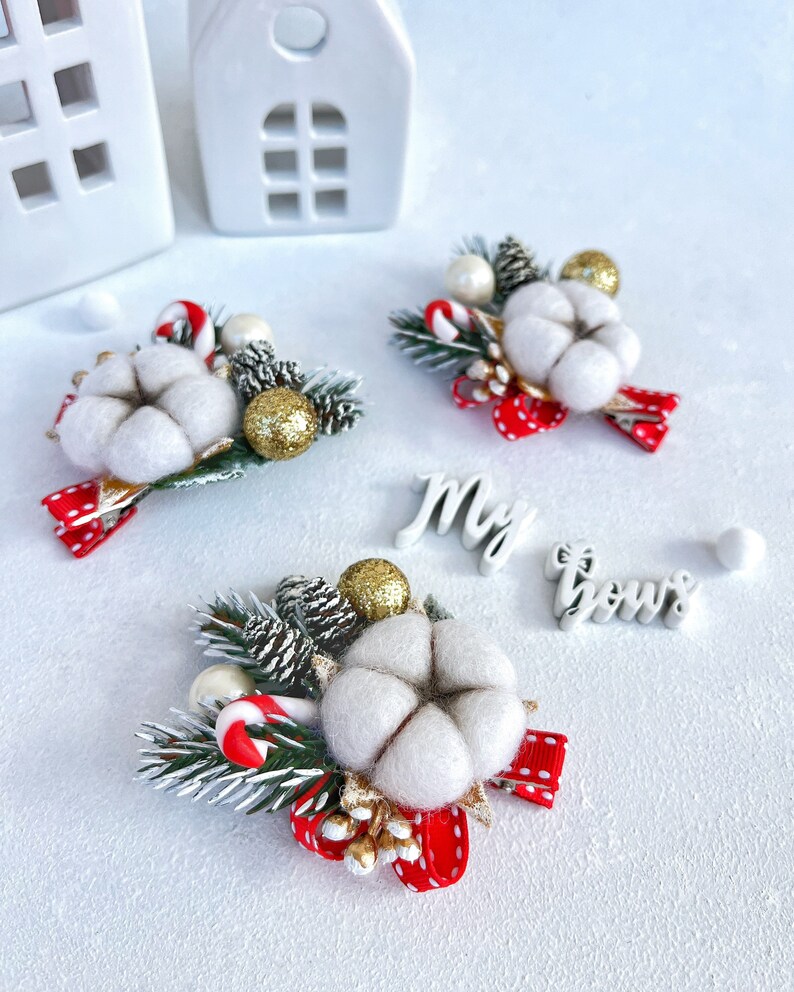 May include: Christmas-themed hair accessories featuring a cotton flower, pine cones, and a red polka-dot bow. Accented with gold glitter balls and candy canes. The text "My bows" is also visible.