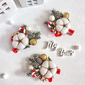 May include: Three Christmas-themed decorative arrangements featuring cotton flowers, pinecones, and candy canes. Each arrangement includes a red ribbon and gold accents. The text "My bows" is also visible.