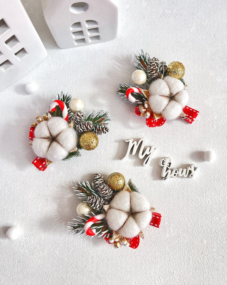 May include: Three Christmas-themed decorative arrangements featuring cotton flowers, pinecones, and candy canes. Each arrangement includes a red ribbon and gold accents. The text "My bows" is also visible.