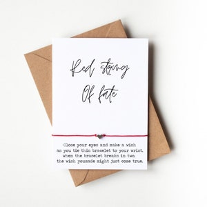 May include: Red string bracelet with the text "Red string of fate" and the message "Close your eyes and make a wish as you tie this bracelet to your wrist, when the bracelet breaks in two, the wish you made might just come true."