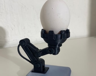 Bras de préhension robotique en forme de coquetier amusant, coquetier amusant comme gag inhabituel, coquille d'œuf inhabituelle comme idée cadeau spéciale