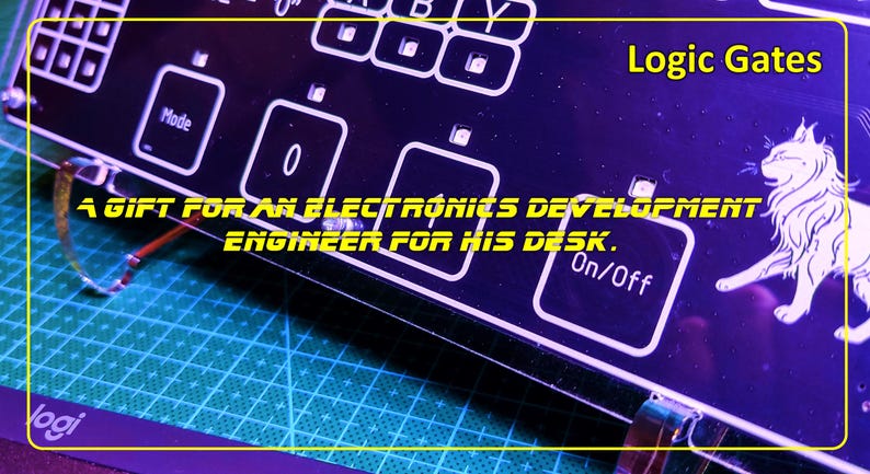 May include: A black acrylic panel featuring white printed labels including Logic Gates, Mode, 0, 1, and On/Off, with a white line drawing of a cat. The text A GIFT FOR AN ELECTRONICS DEVELOPMENT ENGINEER FOR HIS DESK is printed across the centre.