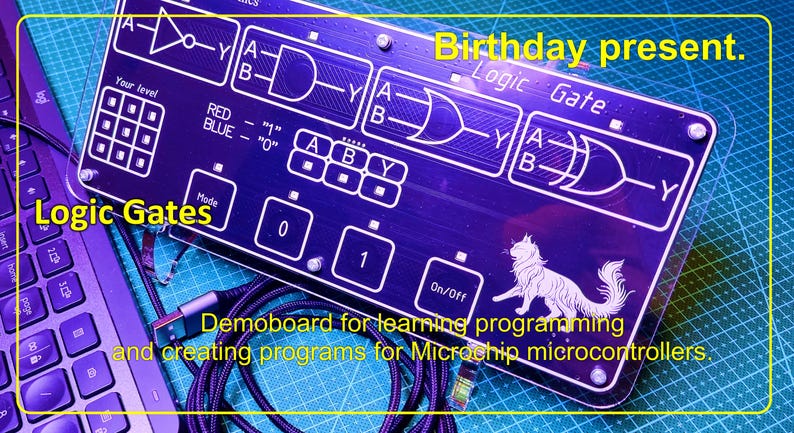 May include: A rectangular dark blue logic gate learning board featuring white printed circuit diagrams, logic symbols, and the text 'Logic Gate', 'Birthday present', and 'Demoboard for learning programming and creating programs for Microchip microcontrollers'.