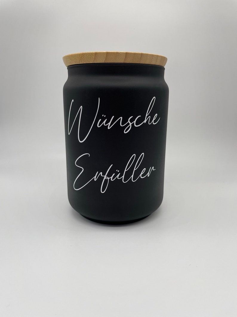 May include: Black jar with a wooden lid and white lettering that says "W&uuml;nsche Erf&uuml;ller".