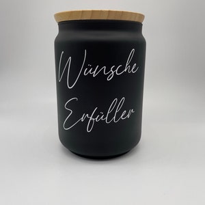 May include: Black jar with a wooden lid and white text that reads "W&uuml;nsche Erf&uuml;ller".