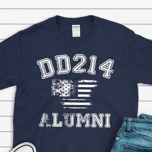 May include: A navy blue t-shirt with white text that reads "DD214 ALUMNI" and a distressed American flag graphic.