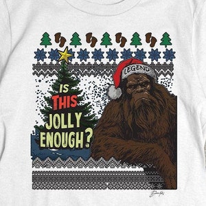 May include: White t-shirt with a Christmas-themed design featuring a Bigfoot wearing a Santa hat and the text "Is this jolly enough?"