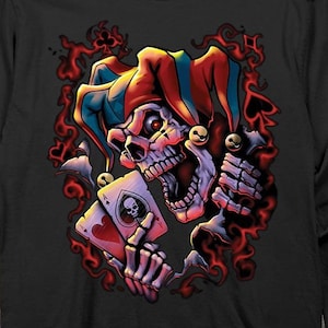 May include: Black long-sleeve t-shirt with a graphic of a skull wearing a jester's hat and holding a playing card. The skull has red and blue accents on the hat and a menacing expression.